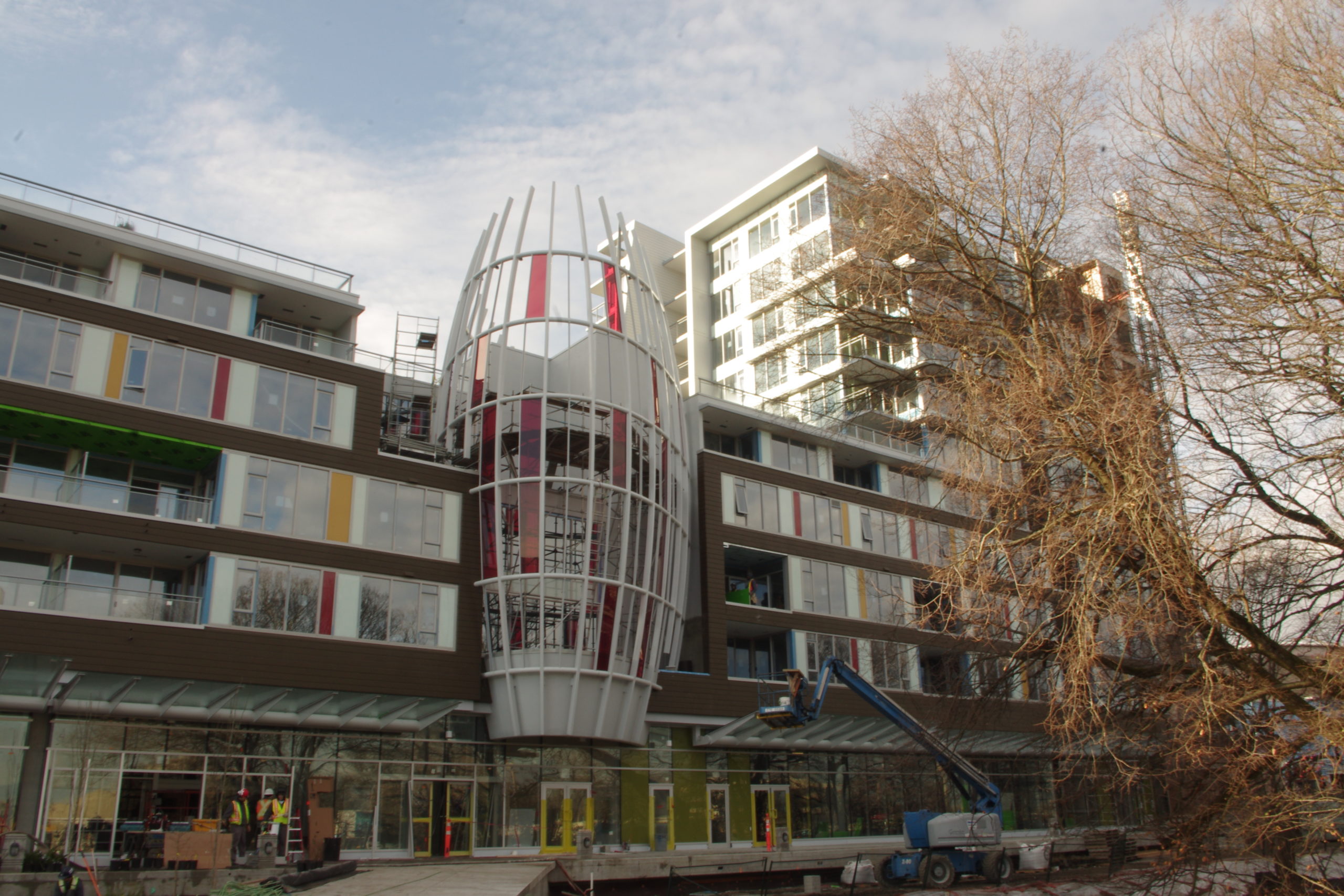 The Ora building looks almost like a regular set of apartments but with a curved, multi-colored cylindrical-shaped feature in the center.