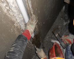 The construction team filling one of the many cracks of leaking water.